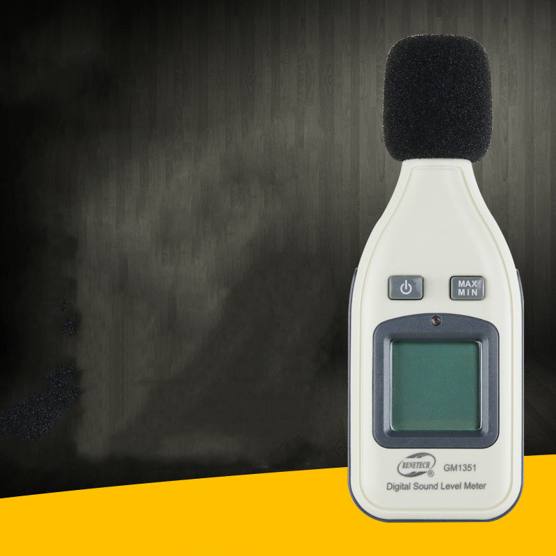 A handheld digital sound level meter with a black microphone cover, buttons, and a digital display showing a reading.