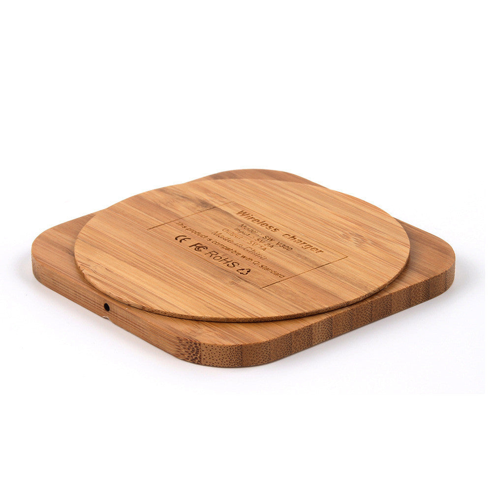 A wooden bamboo wireless charger with a USB port, in a square shape.