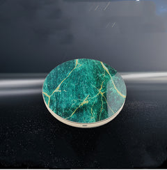 A collection of wireless chargers with a circular design, available in white, black, and green colors, with a marble pattern and a gold edge.