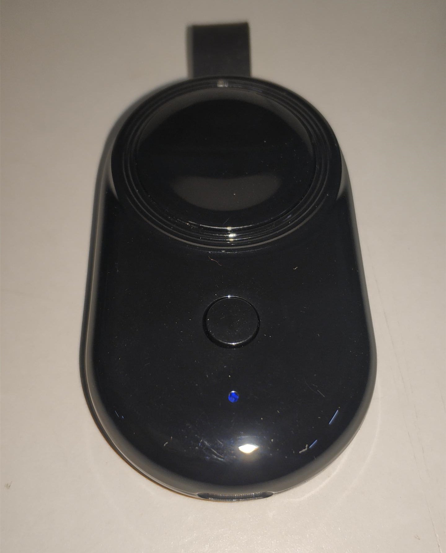 A white wireless charger mounted on a wall, charging a white Apple Watch.